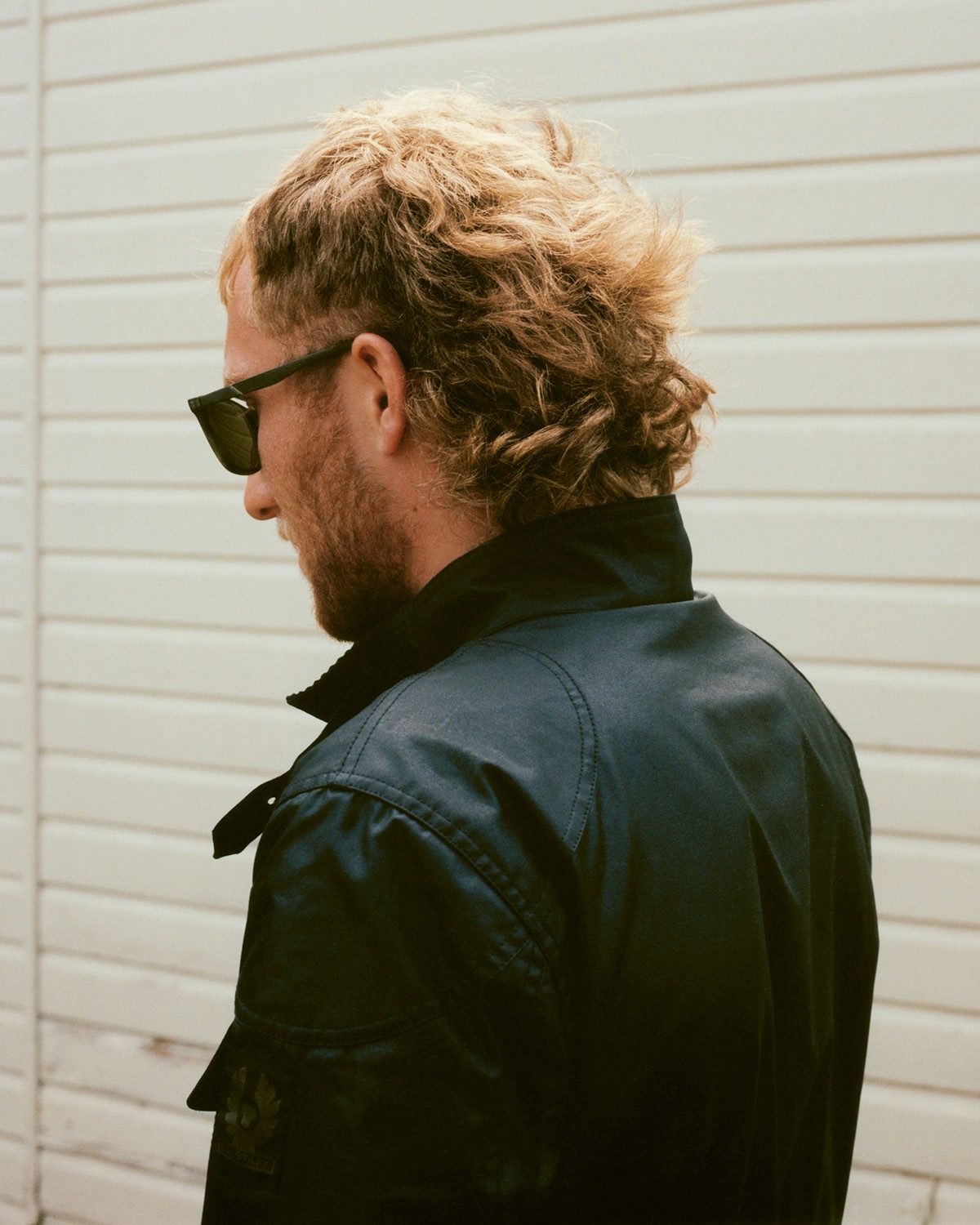 Photo of motorcyclist Sam Lampkin wearing a leather jacket and sunglasses taken from Belstaff centenary book