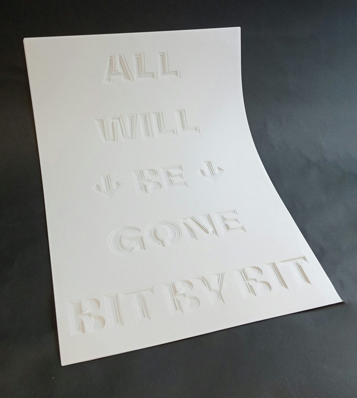 White poster by Ethan Read with the phrase 'all will be gone bit by bit' debossed in the design