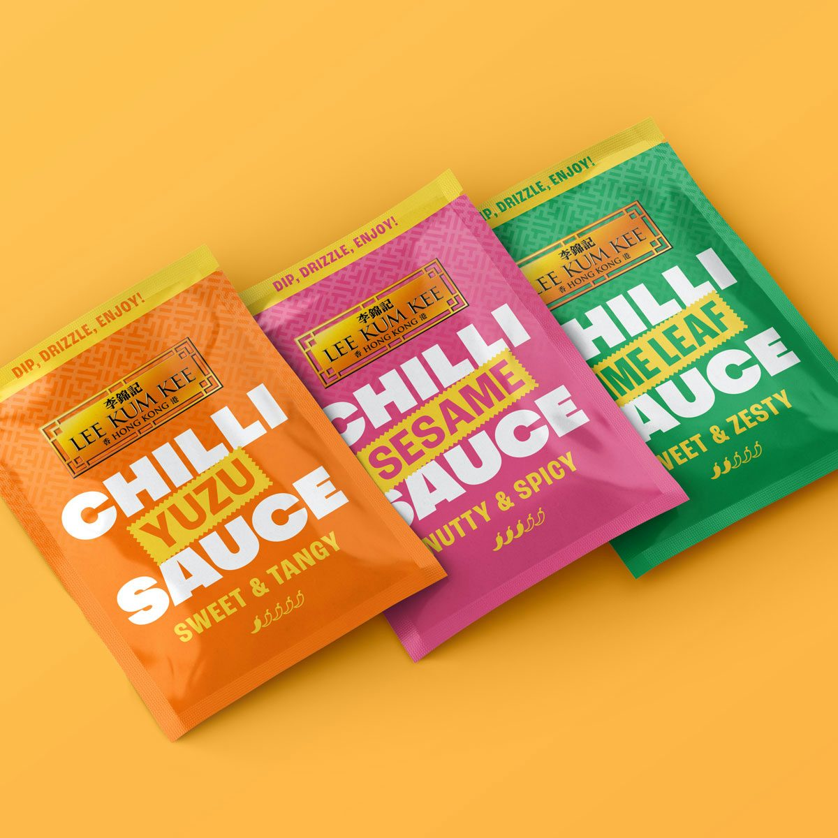Three Lee Kum Kee sauce packs each in an orange, pink and green packaging, shot against a bright orange background